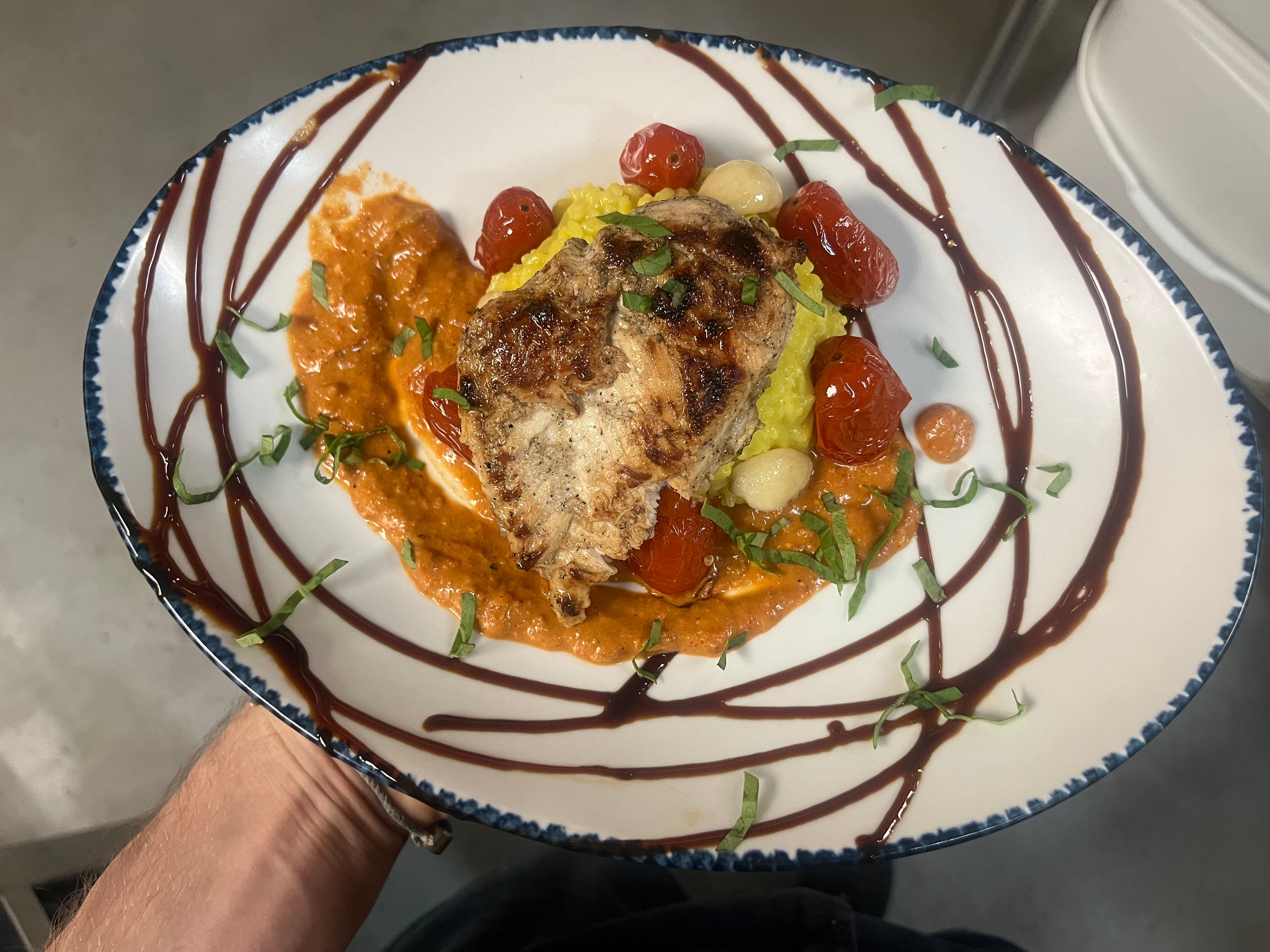 Italian style Chicken seared in tomato-herb infused olive oil w/ creamy saffron rice, confit tomatoes and garlic